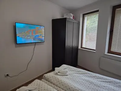 a bedroom with a tv hanging on the wall at 1А1 Apartament in Pamporovo