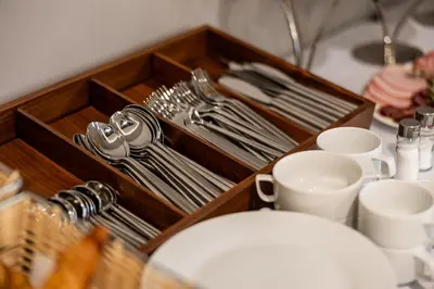 a wooden tray with utensils on a table at Acacia Hotel in Sofia