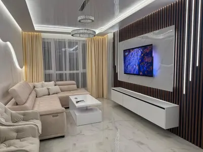 a living room with a couch and a tv on a wall at RICH apartment in Plovdiv