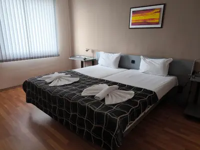 a bedroom with a large bed with two pillows on it at ATM Hotel in Sofia