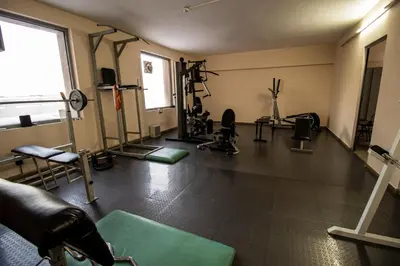 a gym with several treadmills and machines in a room at ATM Hotel in Sofia