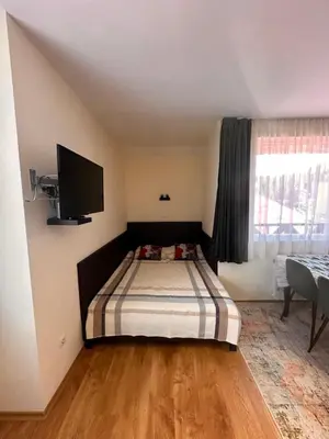 a bedroom with a bed and a flat screen tv at Private large apartment in Iglika 2 for 4 people in Borovets