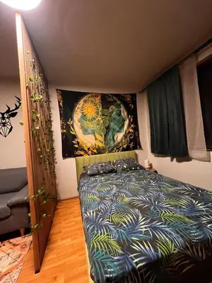 a bedroom with a bed and a painting on the wall at Apartment near the ski lift with a private parking in Bansko