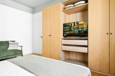 a bedroom with a television in a wooden cabinet at Lift - Duplex - King Beds - 5min to Vitosha in Sofia