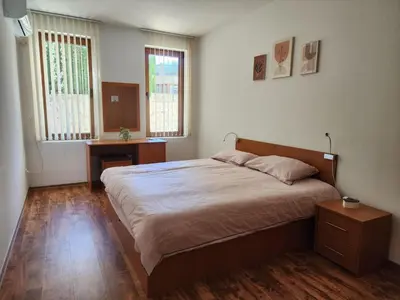 a bedroom with a large bed and two windows at Mountain Dream apartment near ski road in Bansko