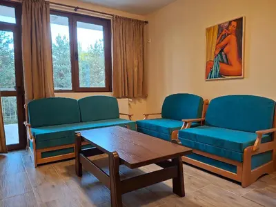 a living room with two blue chairs and a table at Margarita Mountain Apartments in Tsigov Chark
