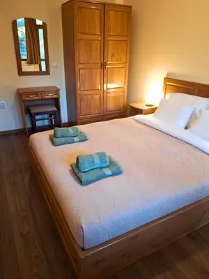 a bedroom with a large bed with two towels on it at Margarita Mountain Apartments in Tsigov Chark