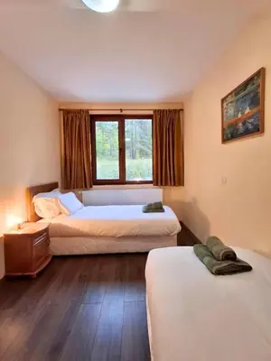a bedroom with two beds and a window at Margarita Mountain Apartments in Tsigov Chark