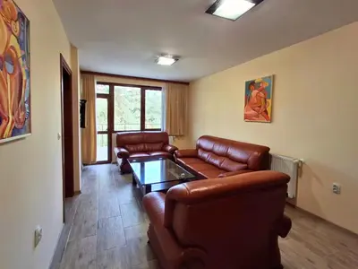 a living room with leather couches and a table at Margarita Mountain Apartments in Tsigov Chark