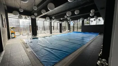 a large swimming pool in a large room with windows at ТРИ ПЛАНИНИ ап113 in Razlog