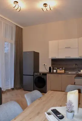 a living room with a table and a kitchen at The Corner apartments in Sofia