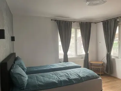 a bedroom with a bed and a window with curtains at Guest House Simona in Sapareva Banya