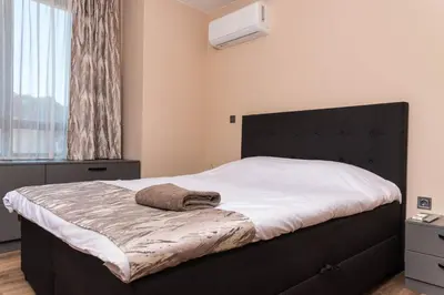 a bedroom with a large bed with a black headboard at Apartment Maritsa View 2 in Plovdiv