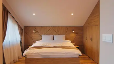a bedroom with a large bed with a wooden headboard at Къща за гости Станковата къща in Belchin