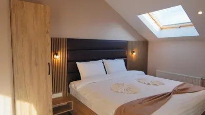 a bedroom with a large bed with a skylight at Къща за гости Станковата къща in Belchin