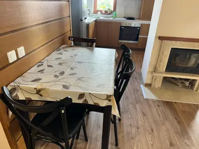 a table and chairs in a kitchen with a fireplace at Апартаменты Гранд Ризорт с камином и видом на лес in Pamporovo