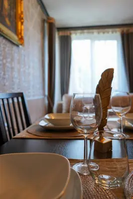 a wooden table with two wine glasses on it at Pirin Elegance Apartment by Gondola Lift in Bansko