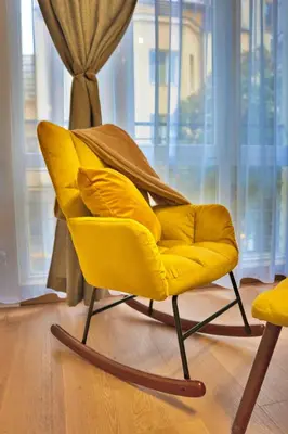 a yellow chair sitting in front of a window at The Heart of Sofia just steps away from Vitoshka in Sofia