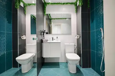 a bathroom with two toilets and a sink and a mirror at N9 Studentski Loft - Cozy Apt with Private Parking in Sofia