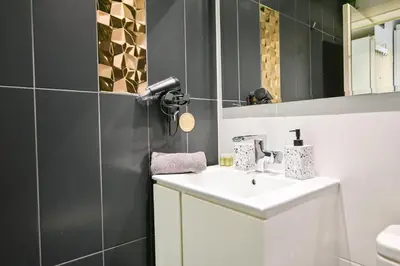 a bathroom with a sink and a mirror at N9 Studentski Loft - Cozy Apt with Private Parking in Sofia
