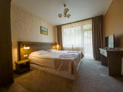 a hotel room with a bed and a window at Апартамент Орфинда- Pamporovo in Pamporovo