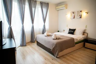 a bedroom with a bed and a large window at Central Sofia Apartment & FREE Underground Garage in Sofia