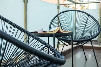 a table and chairs with a coffee cup and a book at Central Sofia Apartment & FREE Underground Garage in Sofia