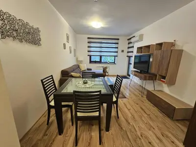 a dining room and living room with a table and chairs at Charming Apartment Borovets Gardens D16 in Samokov