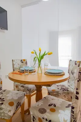 a dining room table with a vase of flowers on it at Студио 8 Уютна Почивка in Hisarya
