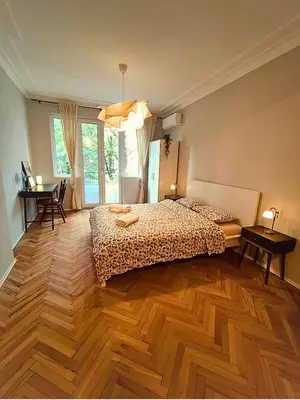 a bedroom with two beds and a wooden floor at Serenity Lodge, close to NDK! in Sofia