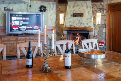 two bottles of wine sitting on a wooden table with candles at Villa TIANA Bansko 7-Bedroom Luxury Chalet in Bansko
