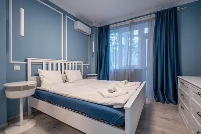 a bedroom with a bed with blue walls and a window at Stylish & Funcional 1 BDRM apt in Sofia's heart in Sofia