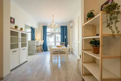 a kitchen and dining room with white cabinets and a table at Stylish & Funcional 1 BDRM apt in Sofia's heart in Sofia