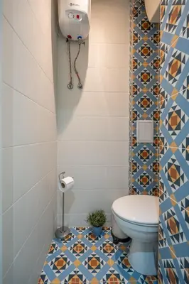 a bathroom with a toilet and a tile floor at Stylish & Funcional 1 BDRM apt in Sofia's heart in Sofia