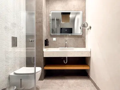 a bathroom with a sink and a toilet and a mirror at Hotel HAYASHI - Free Parking and Fitness in Sofia
