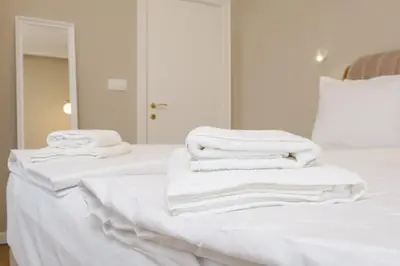 a stack of white towels sitting on a bed at The House of Pom in Plovdiv