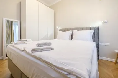 a bedroom with a large bed with white sheets and pillows at The House of Pom in Plovdiv