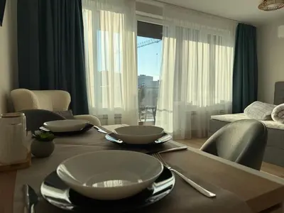 a dining room table with bowls and plates on it at SkyWay by NightSpace- Modern City Apartment in Sofia