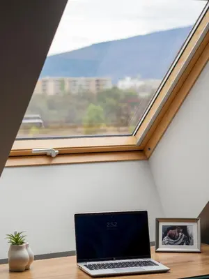 a laptop sitting on a desk in front of a window at Modern Vitosha View Apartment with Free Parking in Sofia