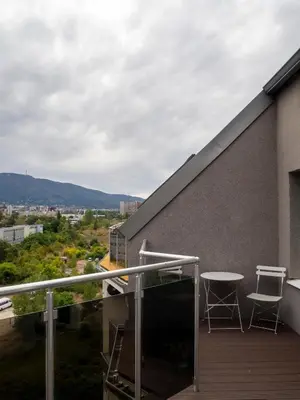a balcony with two chairs and a table on a building at Modern Vitosha View Apartment with Free Parking in Sofia