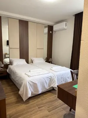 a hotel room with two beds and a table at Комплекс Ванката in Kamena
