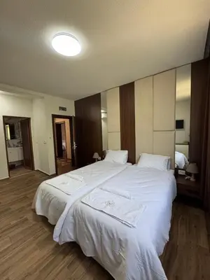 a bedroom with a large white bed with towels on it at Комплекс Ванката in Kamena