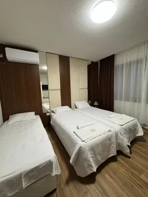a hotel room with two beds with white sheets at Комплекс Ванката in Kamena