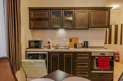 a small kitchen with wooden cabinets and a sink at 2R Ski - ТуЕр Ски in Smolyan