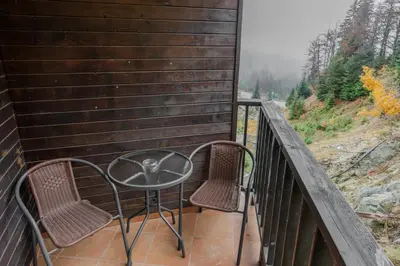 a table and chairs on a balcony with a view at 2R Ski - ТуЕр Ски in Smolyan