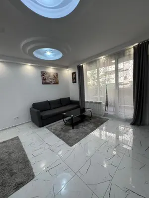 a living room with a black couch and a window at Top Central Apartment 14 in Sofia
