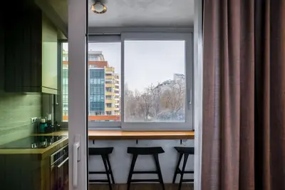 a kitchen with a table and two stools in front of a window at Cozy Apartment in Lozenetz by 7th Sence in Sofia