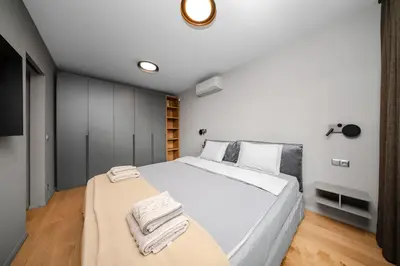 a bedroom with a large white bed with towels on it at Cozy Apartment in Lozenetz by 7th Sence in Sofia