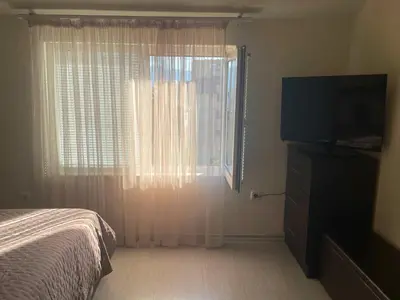 a bedroom with a bed and a window with a television at Lucy in Sandanski