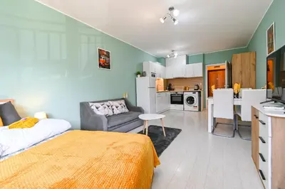 a bedroom with a bed and a kitchen with a table at Armand de Sanelle in Sofia